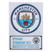 Manchester City logo med skib og rød rose, tekst: "Etihad Stadium M11, Manchester City Football Club".