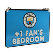 Blåt skilt med Manchester City logo og teksten "#1 FAN'S BEDROOM" i hvid.