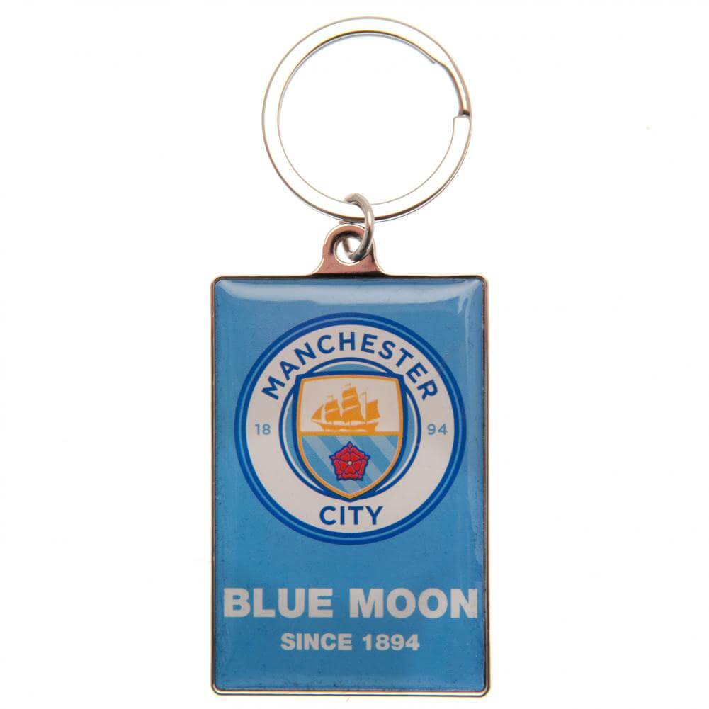 Manchester City nøglering med logo og teksten "BLUE MOON SINCE 1894" på blå baggrund.