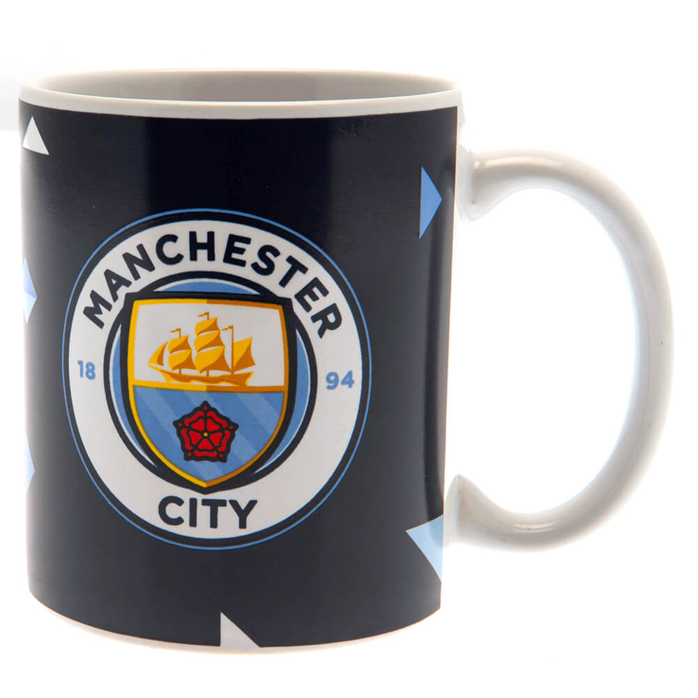 Sort krus med Manchester City-logo, skib, rød rose og årstal 1894 på mørk baggrund.