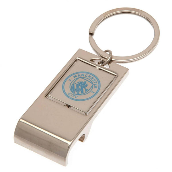 Sølvfarvet nøglering med flaskeåbner og Manchester City logo på forsiden.