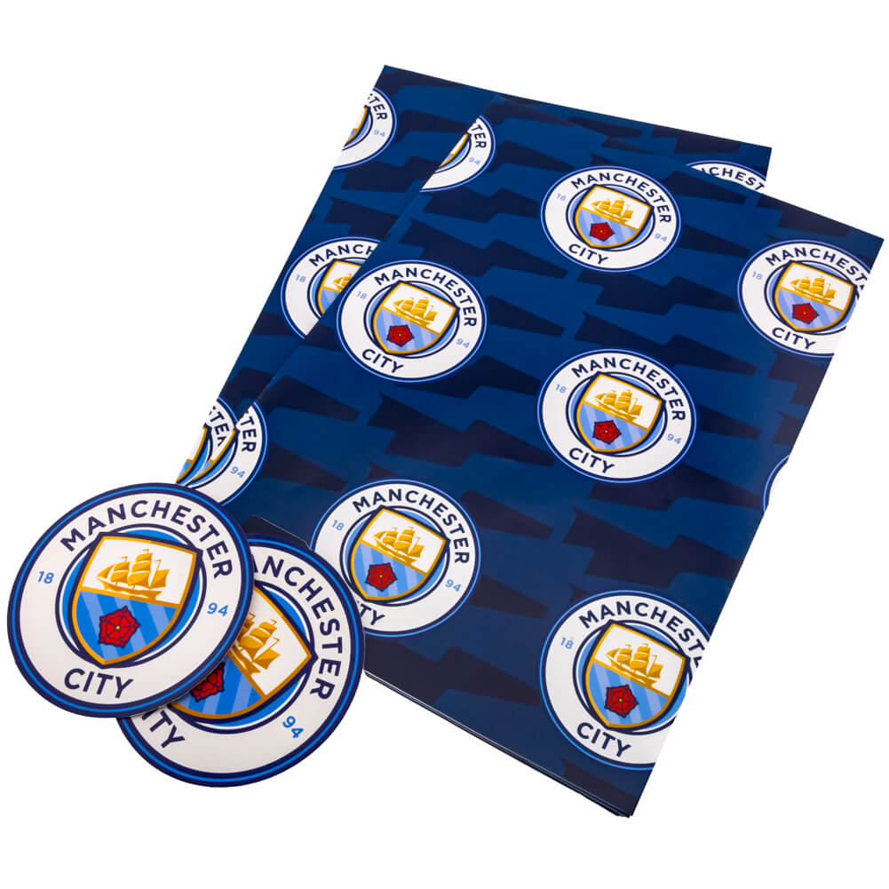 Manchester City gavepapir med klubbens logo gentaget på en blå baggrund.