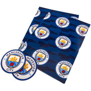 Manchester City gavepapir med klubbens logo gentaget på en blå baggrund.