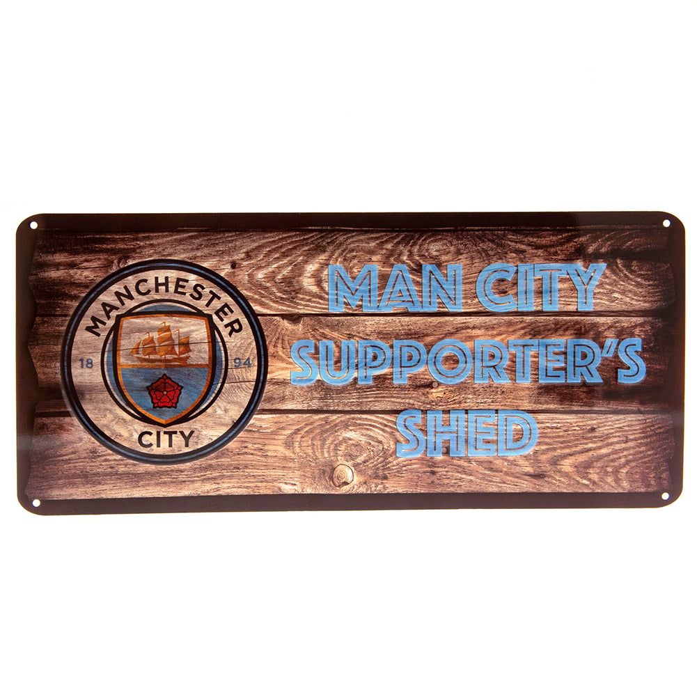 Metalskilt med Man City logo og teksten "SUPPORTER'S SHED" på trætekstur baggrund.