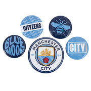 Fem Manchester City pins i blå og hvid med klublogo, bi, "CITY", "CITYZENS" og "BLUE MOON".