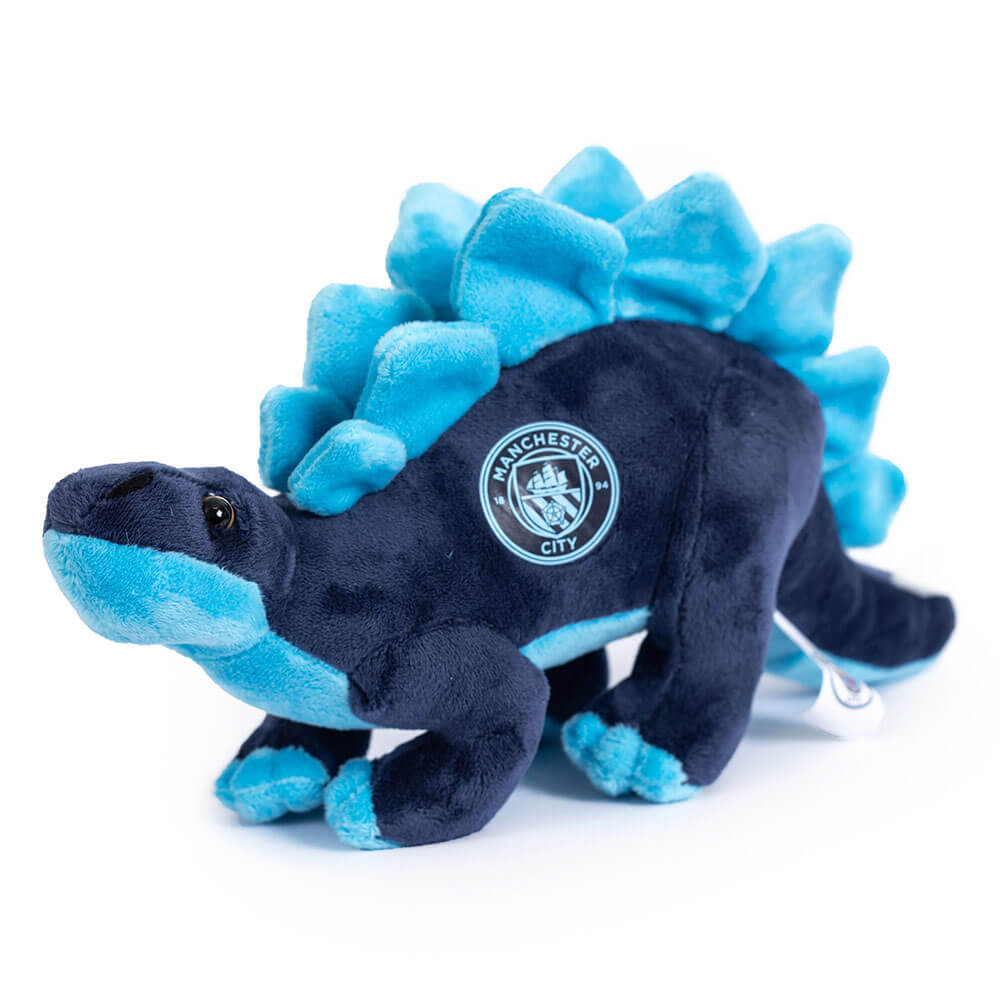 Manchester City Stegosaurus bamse i mørkeblå med lyseblå pigge og logo, stående livagtigt.