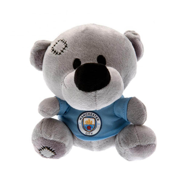 Grå tøjbamse med blå Manchester City-trøje og syninger på hoved og poter, officielt merchandise.