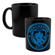 Sort krus med blå Manchester City logo, skib og rose. To krus vises fra forskellige vinkler.