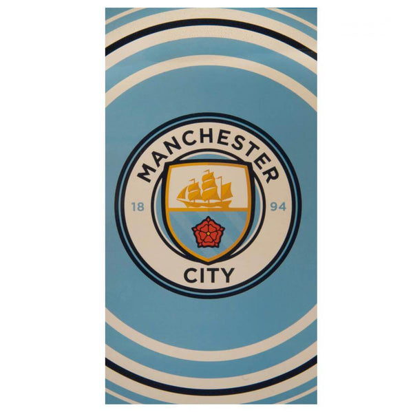 Manchester City håndklæde med klublogo på blå baggrund og hvide samt sorte buede striber.