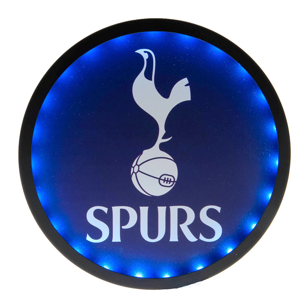 Rundt Tottenham-logo med hane på bold, oplyst af blå LED-lys. Teksten "SPURS" vises nedenfor.