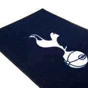 Tottenham Hotspur tæppe med hvidt logo af en hane på en bold, mørk navy baggrund.