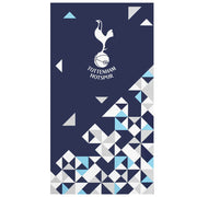 Mørkeblåt håndklæde med Tottenham Hotspur-logo og geometriske mønstre i hvid, lyseblå og grå.