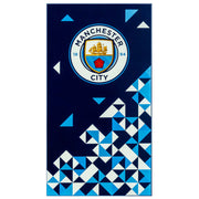 Manchester City håndklæde med logo og geometriske mønstre på mørk baggrund.