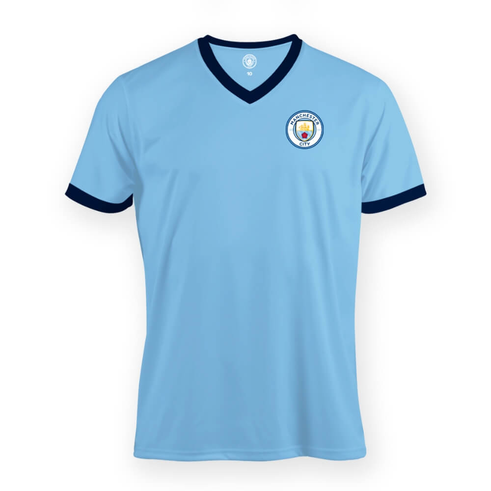 Lys blå Manchester City børne-T-shirt med mørkeblå kanter, V-hals og klublogo på venstre bryst.