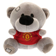 Grå bamse med rød Manchester United-trøje, stor næse, små øjne og syede detaljer på hoved og fod.